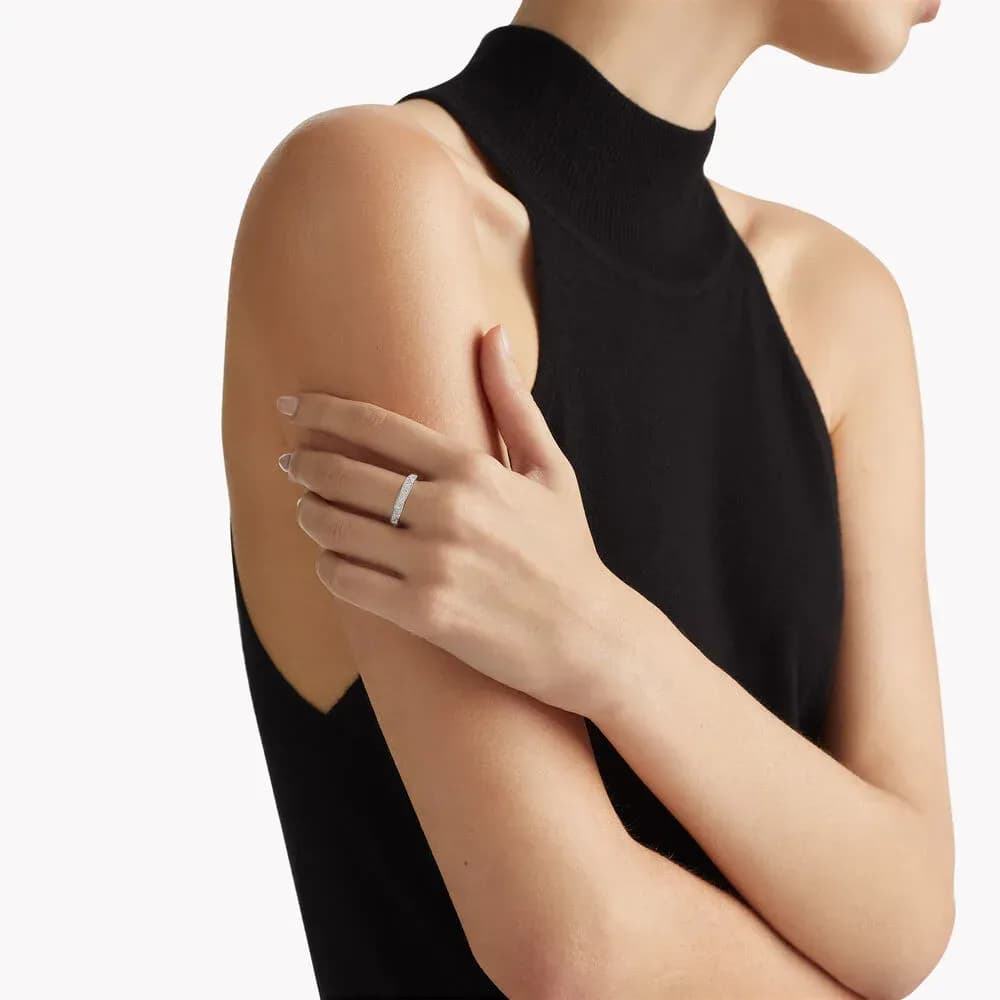 The ring worn, arm folded across a black top